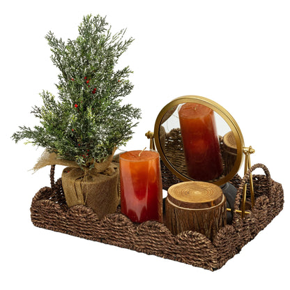 Seagrass tray showcasing a decorative arrangement with candles, a mirror, and a miniature tree for elegant home decor.